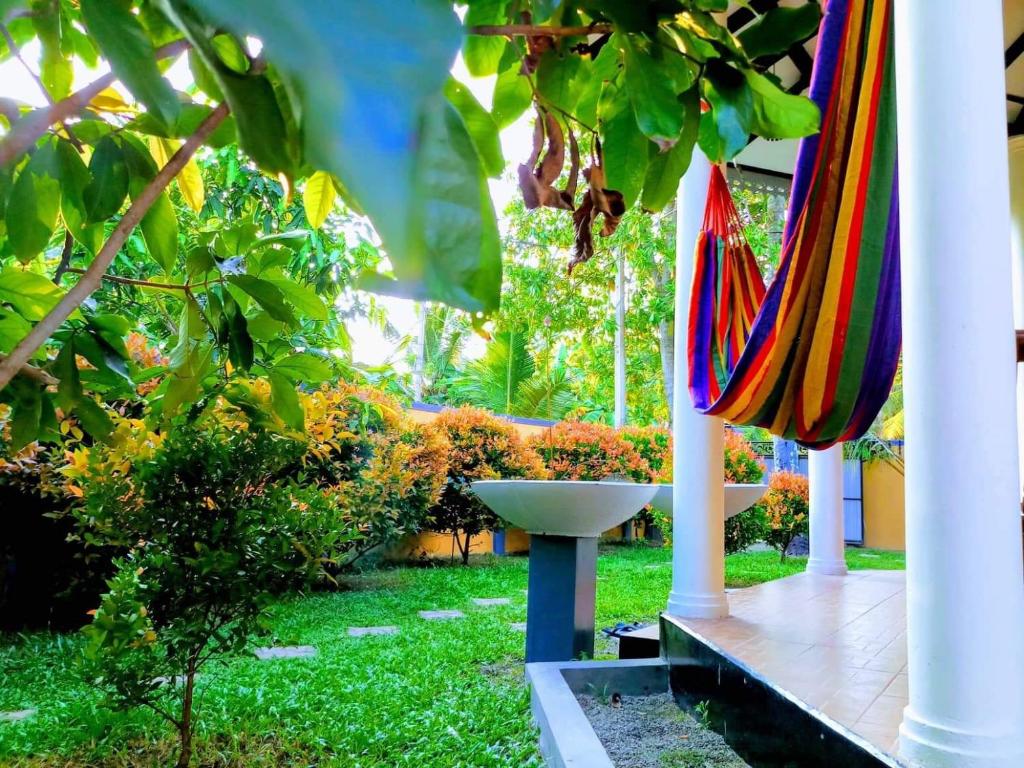 a colorful umbrella and a sink in a garden at Rovenluck Eco Cabana in Weligama