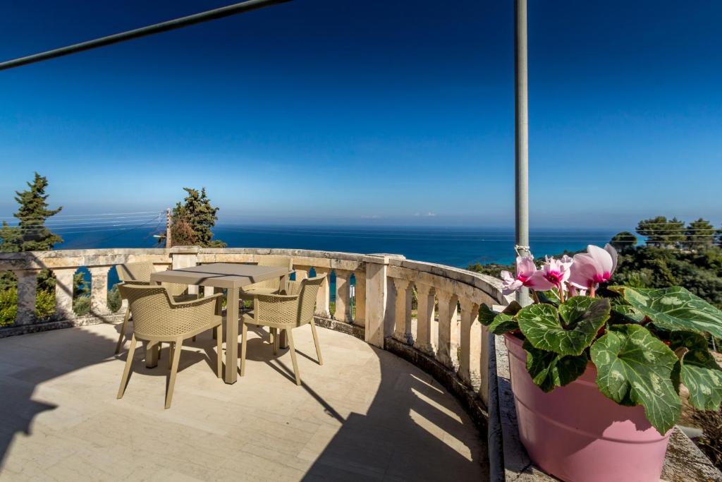 eine Terrasse mit einem Tisch, Stühlen und Meerblick in der Unterkunft Blue Horizon Studios in Vasilikos