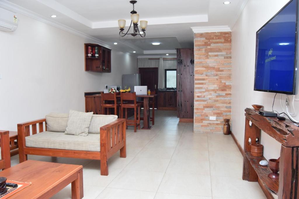 sala de estar con sofá y TV en Upland Estates Serviced Apartments, en Lusaka