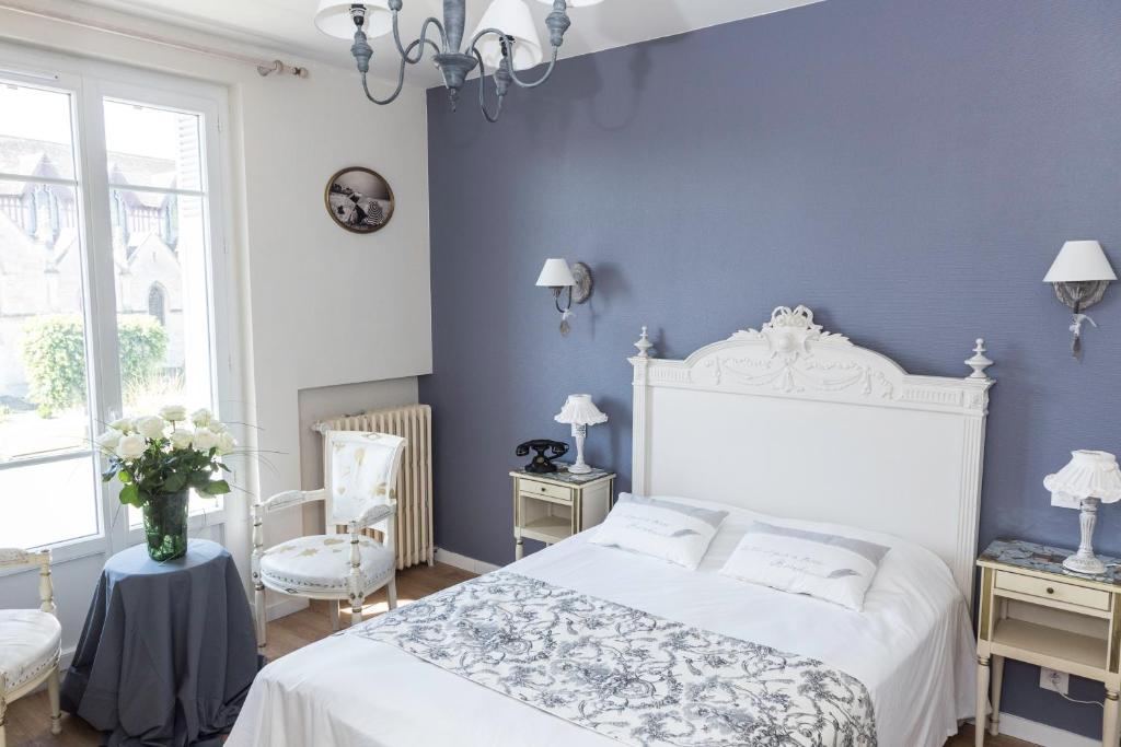 a bedroom with a white bed and blue walls at La Villa Les Mots Passants in Cabourg