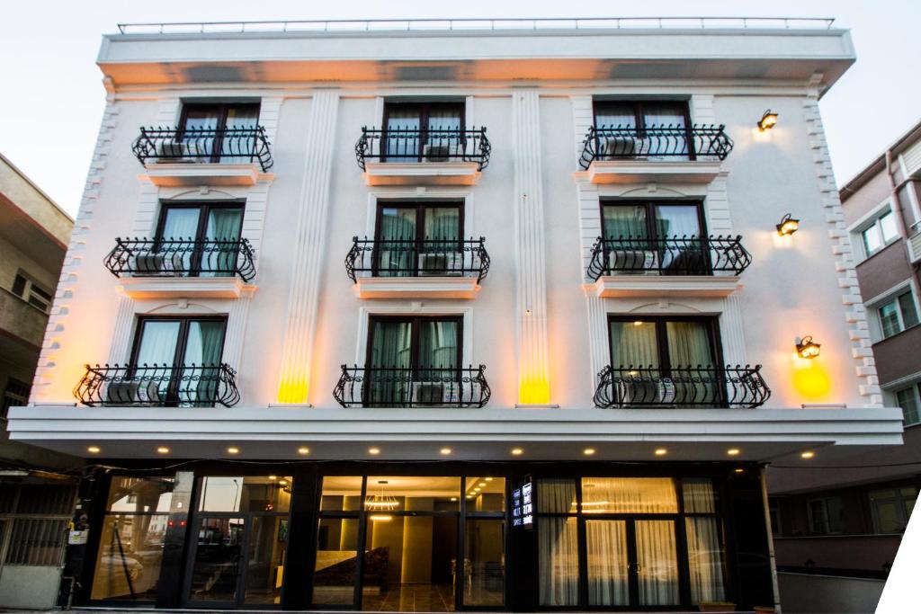 アヴシラーにあるHit Suites Avcilar Hotelの窓とバルコニーが備わる白い建物です。