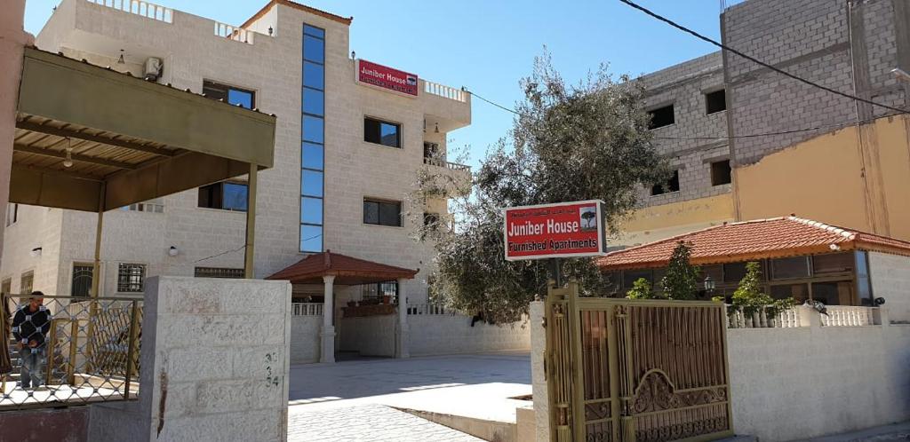 a building with a sign in the middle of a street at Juniper House in Wadi Musa