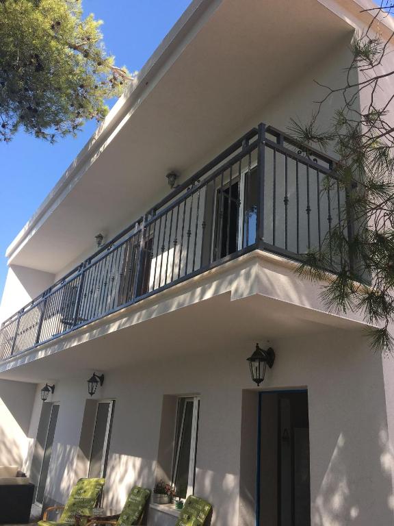 a white house with a balcony on top of it at House Kupina in Gdinj