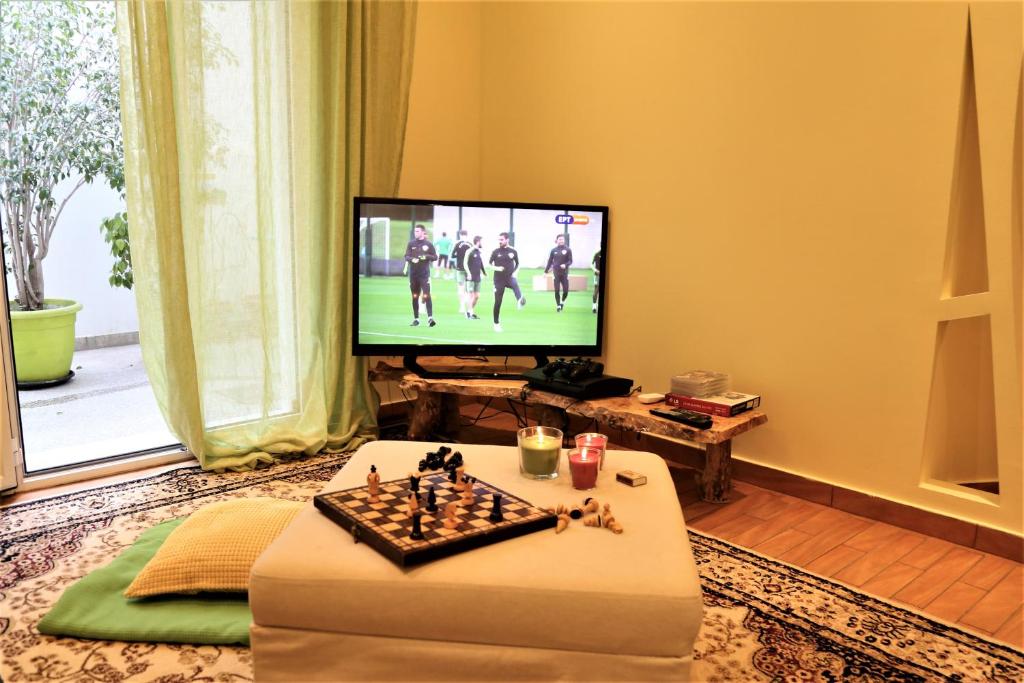a living room with a television and a chess board at Harmony in Athens