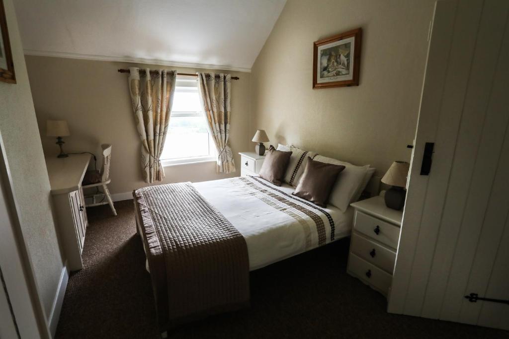 a hotel room with a bed and a window at Green Meadow Farm Holiday Homes in Wicklow