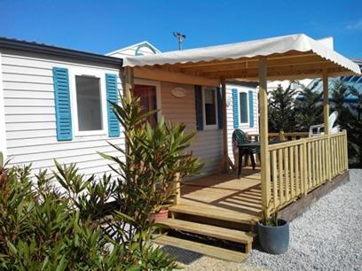 a small house with a porch and a deck at Camping Ensoya in Sigean