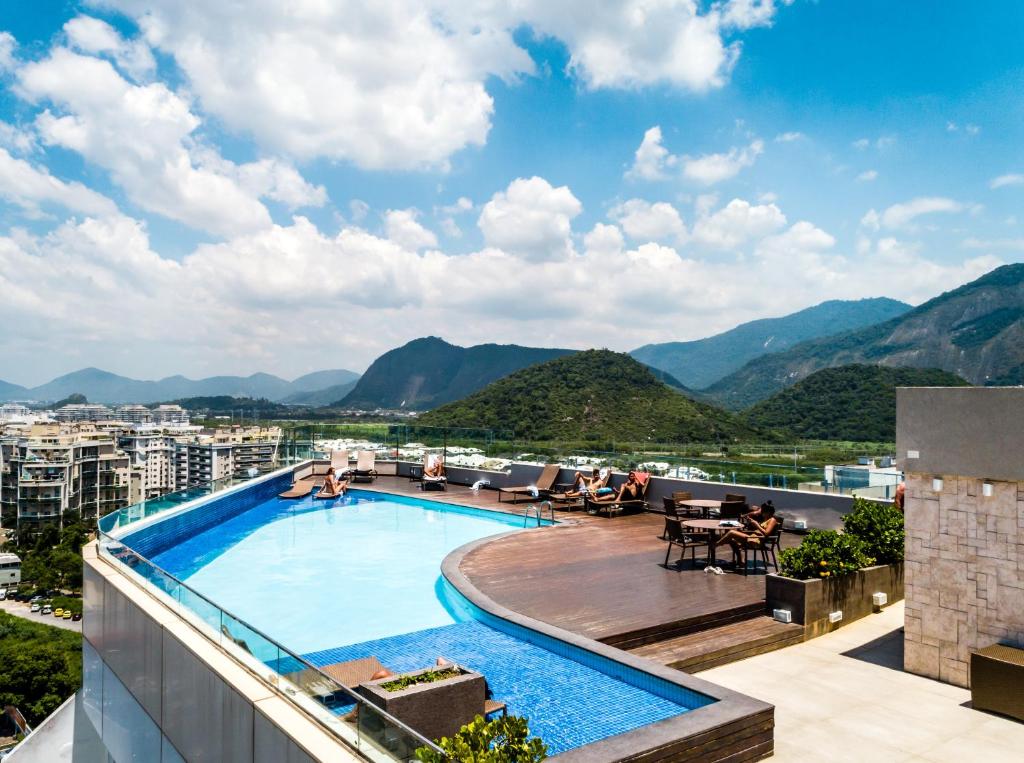 a swimming pool on top of a building with mountains at Américas Barra Hotel in Rio de Janeiro