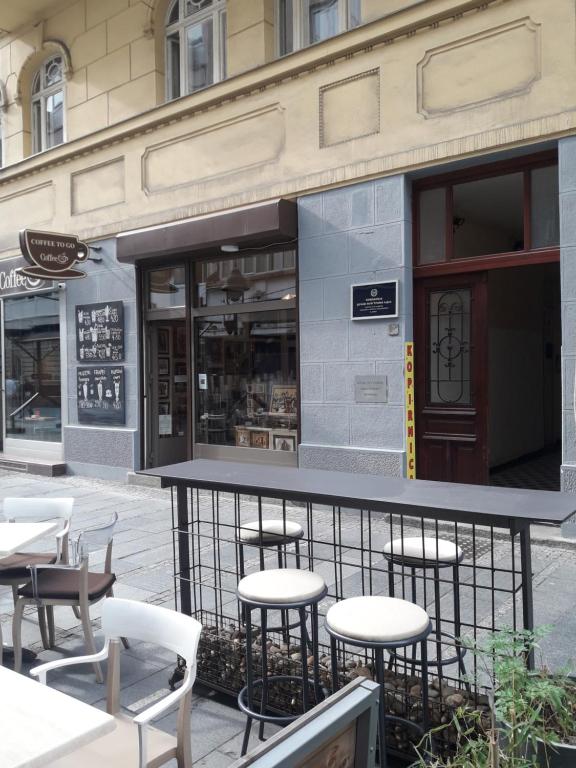 a bar with white chairs and tables on a street at Apartment Ema in Belgrade
