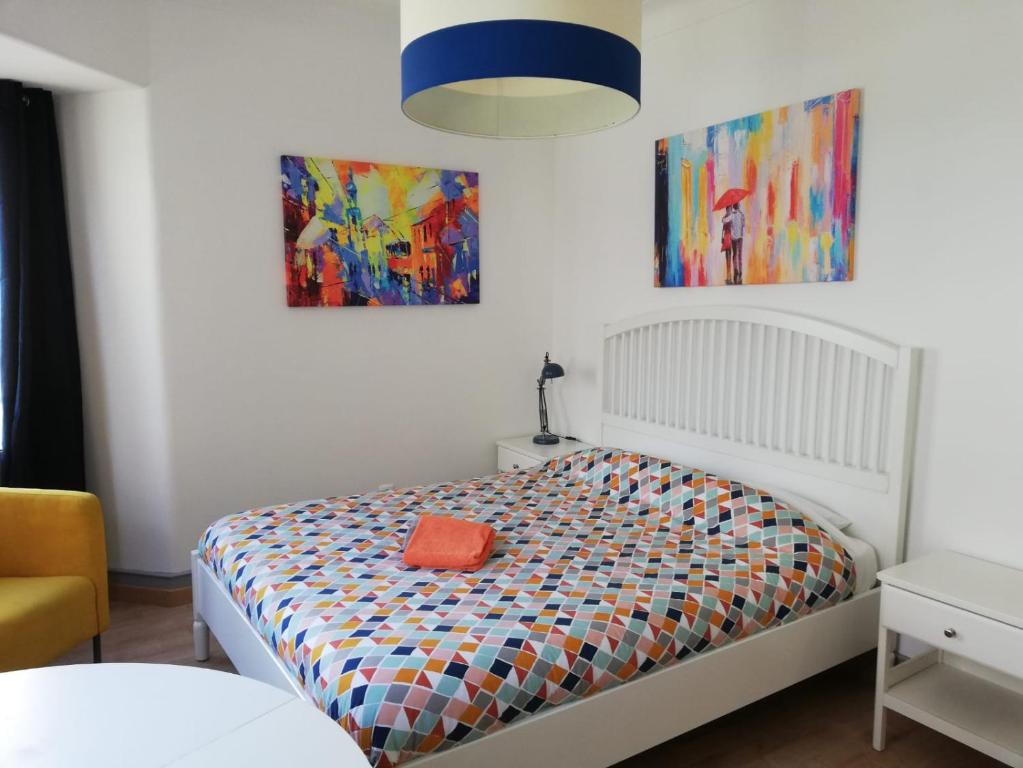 1 dormitorio con 1 cama y 2 cuadros en la pared en BED&SHOWER Moscavide -Self Check-In, en Lisboa