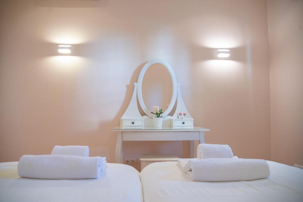 a bathroom with two white beds and a mirror at Colina Verde Resort in Moncarapacho