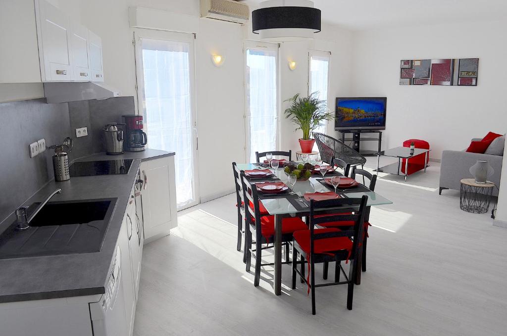 uma cozinha e sala de estar com mesa e cadeiras em Duplex Liberté Plein Centre em Saint-Raphaël