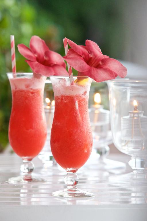 a group of three vases with flowers in them on a table at Cobblers Cove - Barbados in Saint Peter