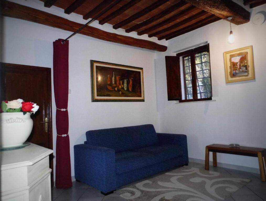 a living room with a blue couch and a window at CASA SERENA in Montepulciano