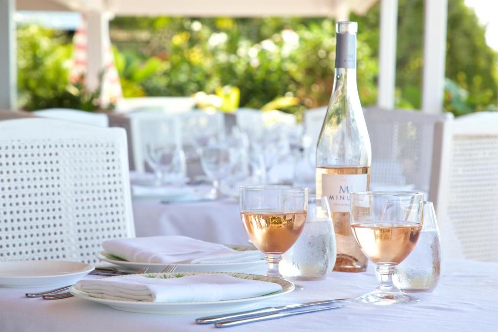 a table with a bottle of wine and two glasses at Cobblers Cove - Barbados in Saint Peter