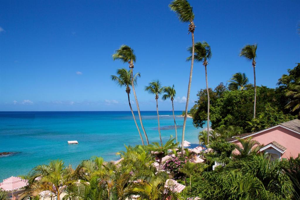 a view of a beach with palm trees and the ocean at Cobblers Cove - Barbados in Saint Peter