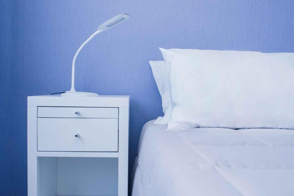 eine weiße Lampe auf einem Nachttisch neben einem Bett in der Unterkunft Gaurez in Buenos Aires