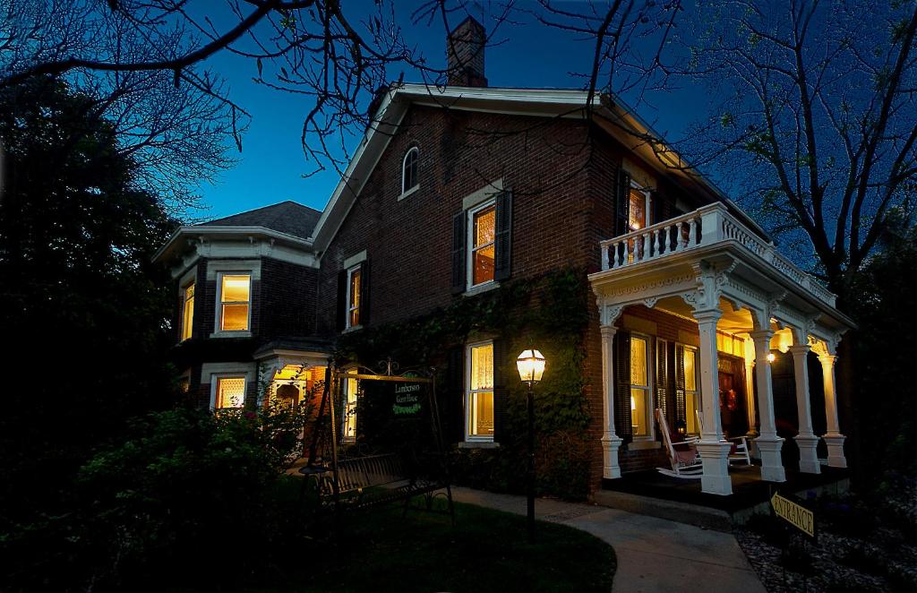 uma grande casa de tijolos com luzes acesas à noite em Lamberson Guest House em Galena