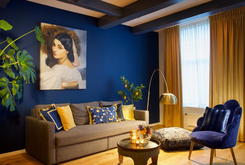 a living room with a couch and a painting of a woman at Haarlem Hotel Suites in Haarlem