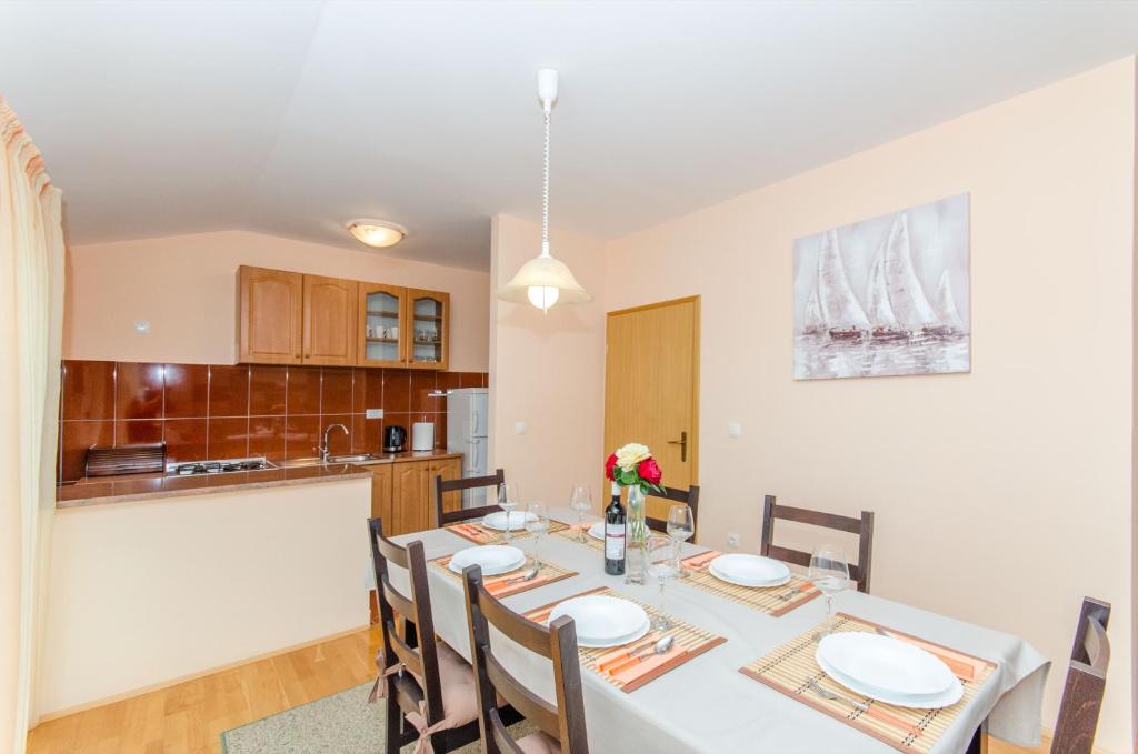 a kitchen and dining room with a table and chairs at Apartman Ivan in Kaštela
