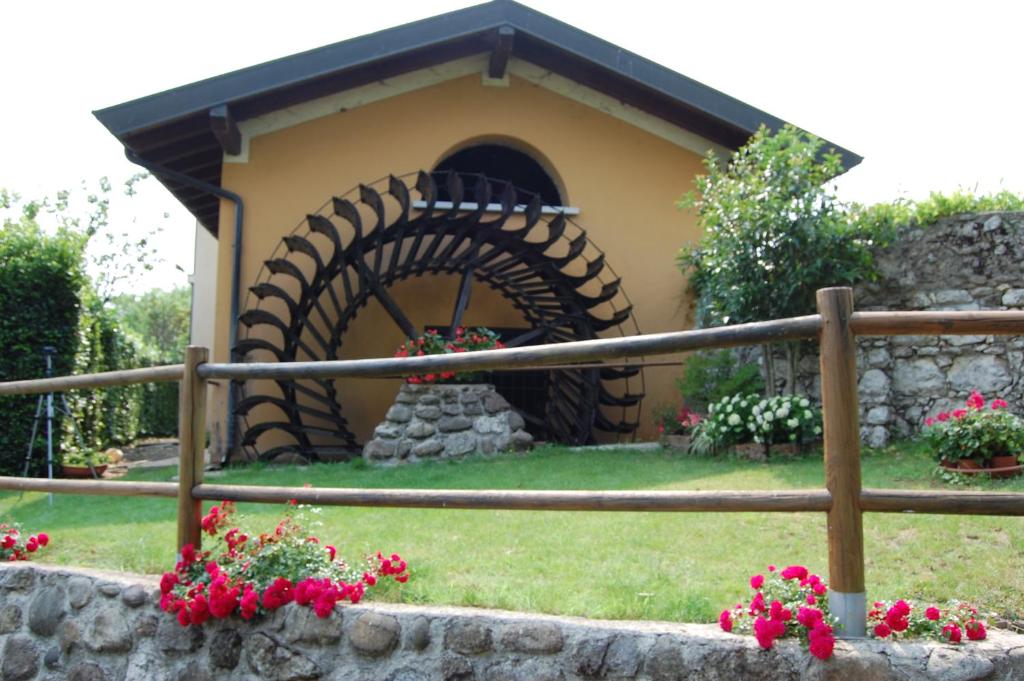 een klein huis met een stenen oven in een tuin bij B&B Al Mulino in Nuvolento