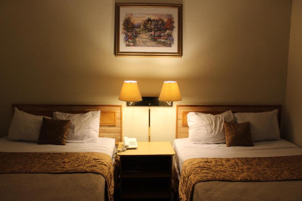 two beds in a hotel room with two lamps at Hotel Mediterraneo Plaza in San Salvador