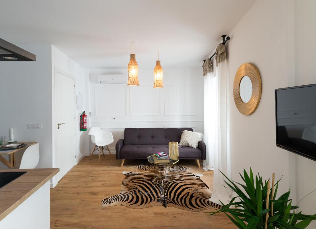 a living room with a couch and a zebra rug at Bohórquez Rooms by Ático73 in Medina Sidonia