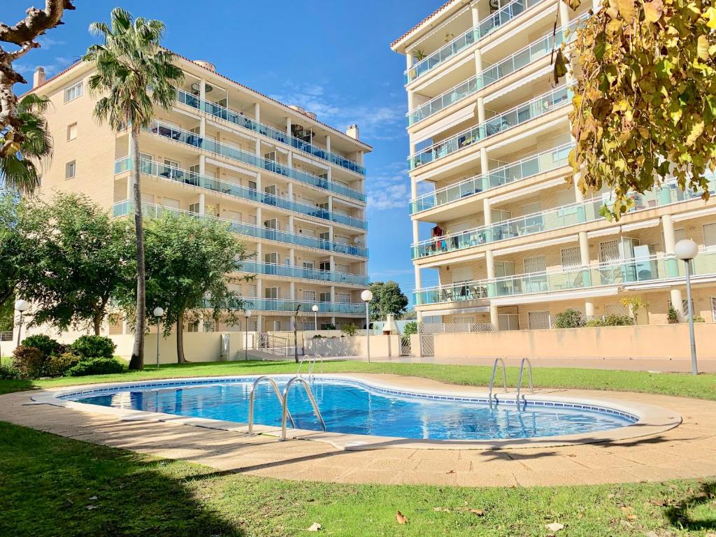 una piscina frente a un gran edificio de apartamentos en APARTAMENTO - WIFI FREE - PISCINA 250 M PLAYA, en Cambrils