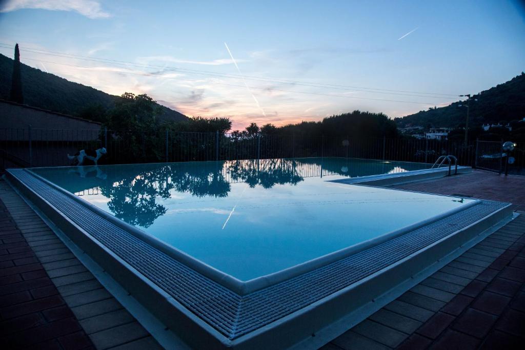 einem Pool mit Spiegelung des Himmels im Wasser in der Unterkunft Vistamare La Fonte in Nisporto