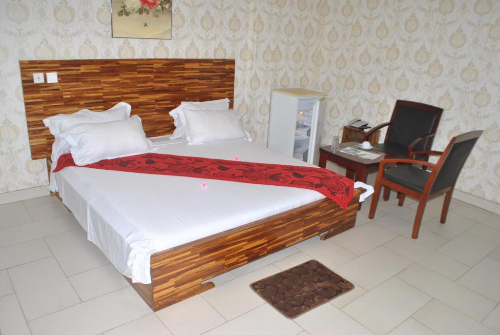 A bed or beds in a room at White Horse Hotel Cotonou