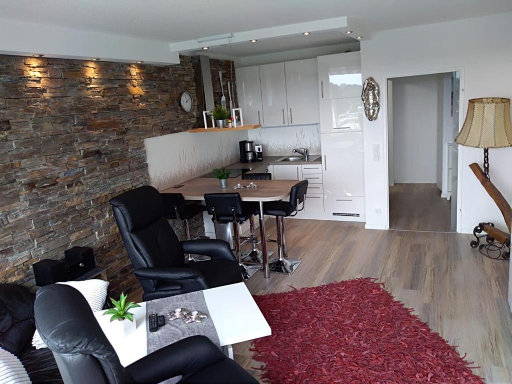 a kitchen and a living room with a table and chairs at Kiel - Schilksee Ferienwohnung Kasing inkl WLAN bezogene Betten und Handtücher in Schilksee