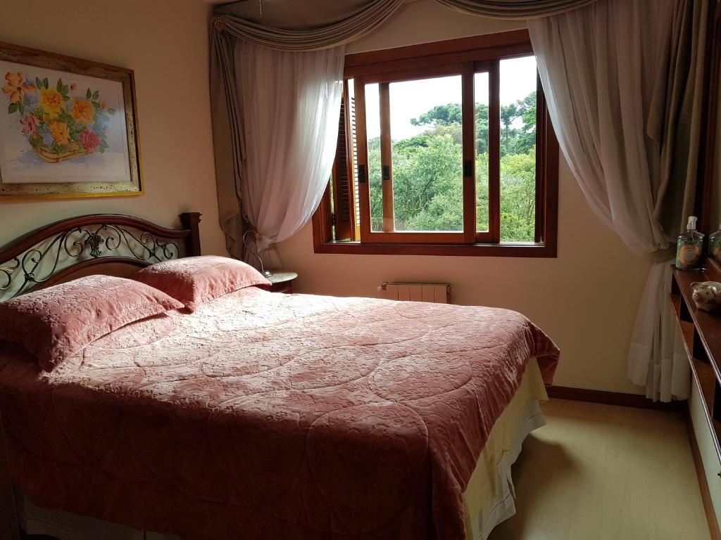 ein Schlafzimmer mit einem großen Bett und einem Fenster in der Unterkunft Apartamento Monte Bianco in Gramado