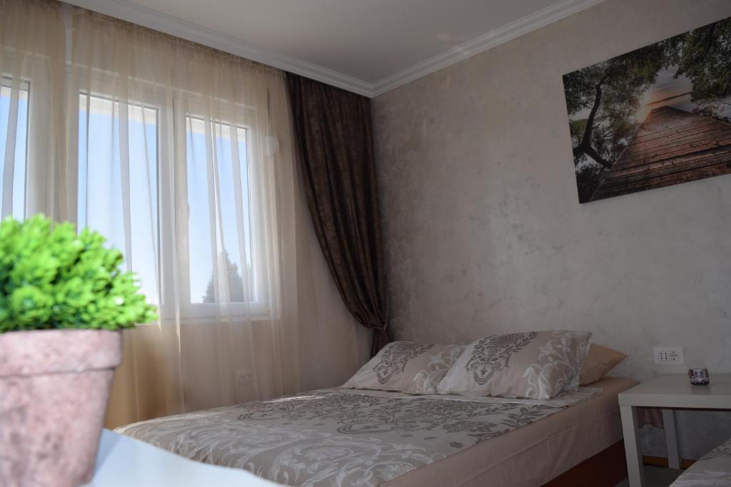 un dormitorio con una cama y una ventana en Apartman Bloom, en Bar
