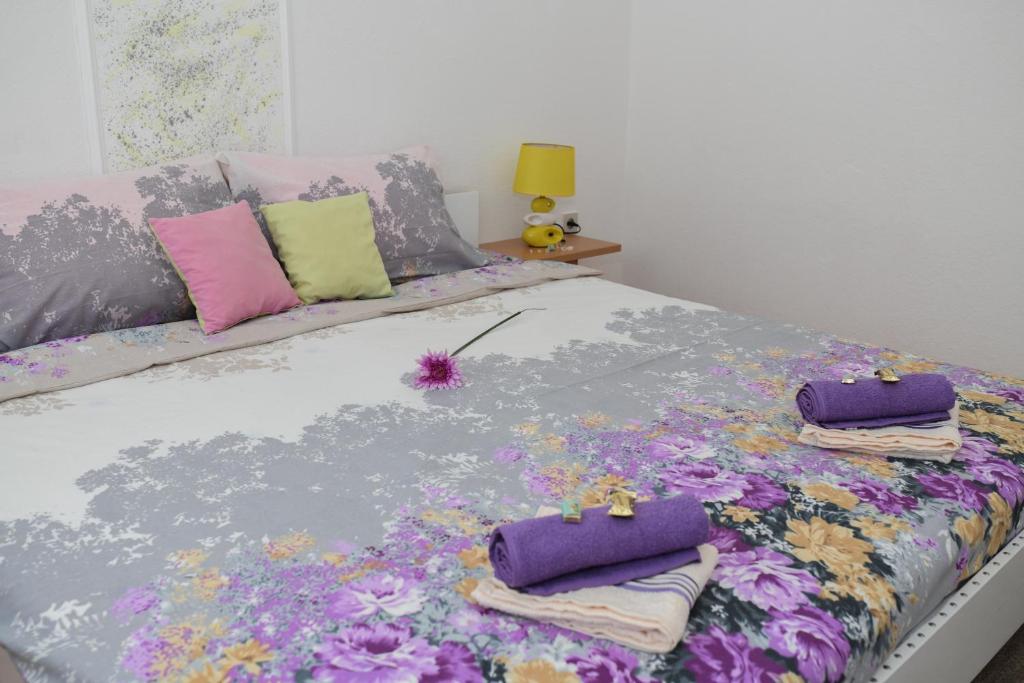 a bed with purple and colorful pillows on it at Apartman Maja in Trebinje