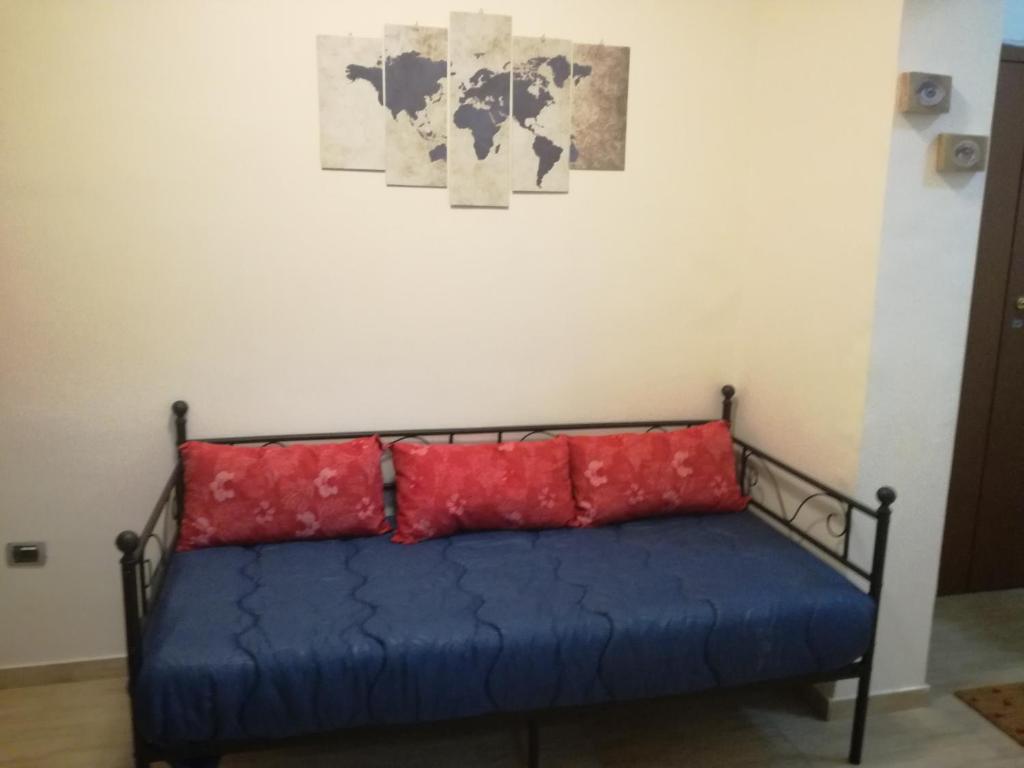 uma cama com quatro almofadas vermelhas num quarto em Badia em Aversa
