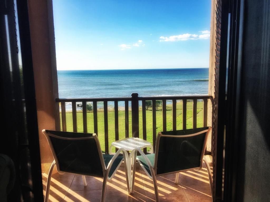 Un balcón con mesa y sillas y el mar. en San Marcos 124 Gran Pacifica Resort, en San Diego