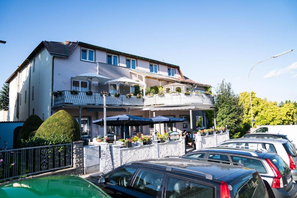 a building with cars parked in a parking lot at Pension & Restaurant La Amalia in Bad Sauerbrunn