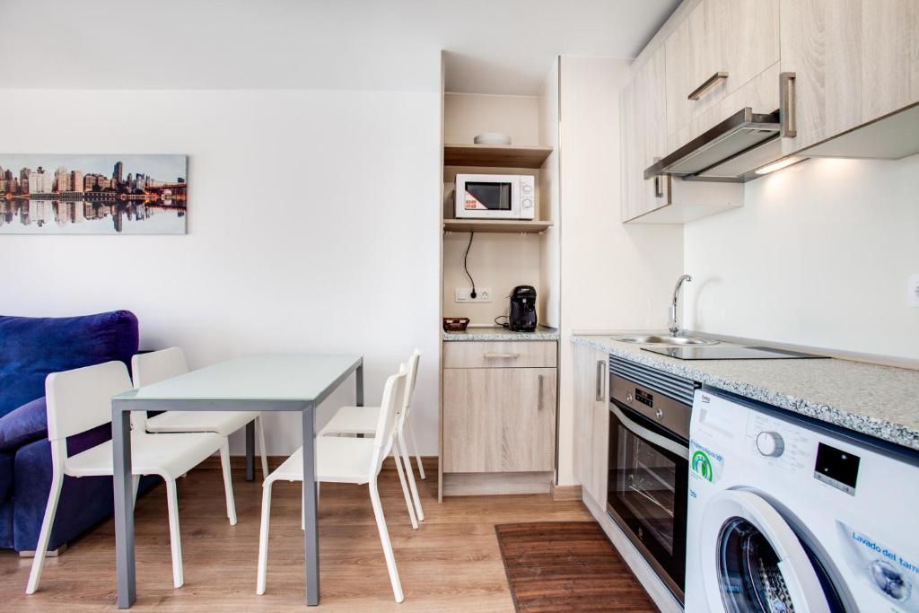 a kitchen and dining room with a table and a dishwasher at Vistas al Mar in Alicante