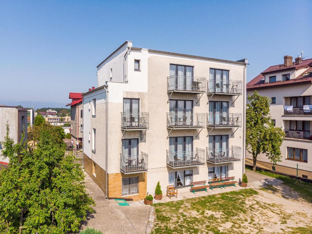 an apartment building with balconies and a yard at Dom Wczasowy Marlon in Jastrzębia Góra