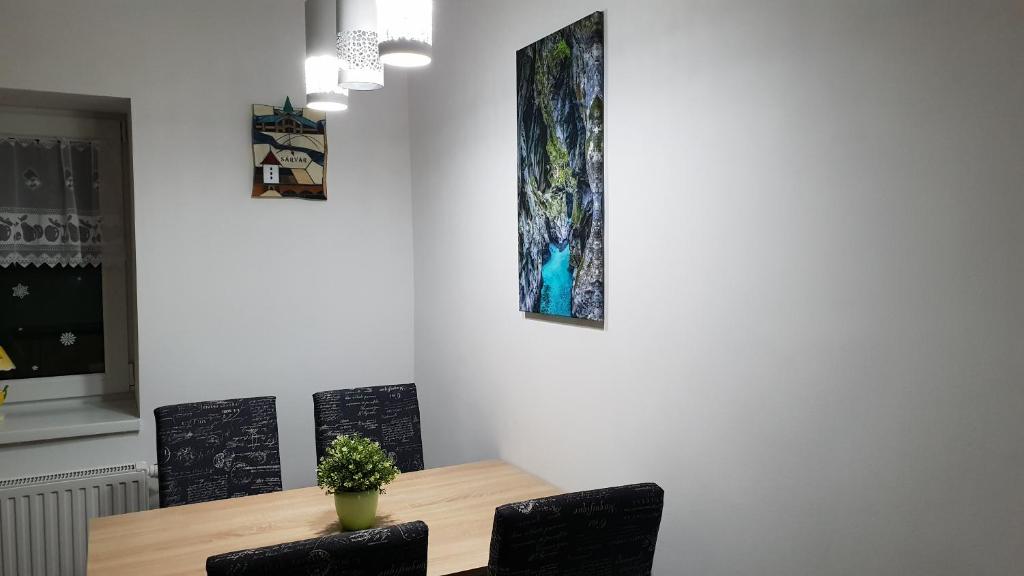 シャールヴァールにあるRelax Apartments Sárvár A4のダイニングテーブル(椅子付)が備わります。壁には絵画が飾られています。