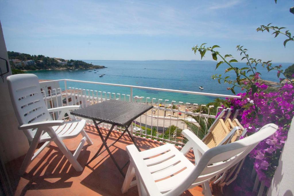 a balcony with chairs and a table and the ocean at Santa Llucia Apartaments in Roses