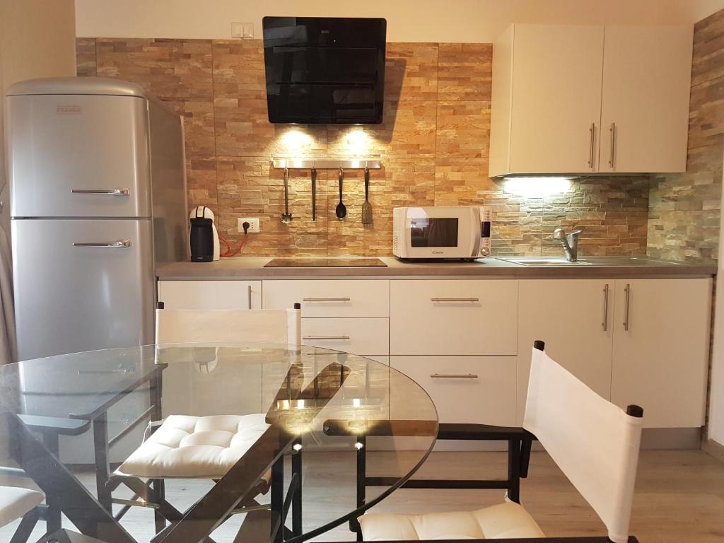 uma cozinha com uma mesa de vidro e um micro-ondas em Moro Dal Castel - Appartamento Al Moro em Castelnuovo del Garda