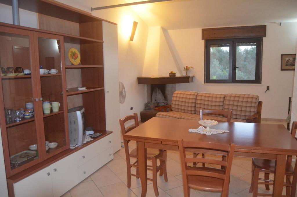 una cucina e una sala da pranzo con tavolo e sedie di Villetta Sakapo' a Corigliano dʼOtranto