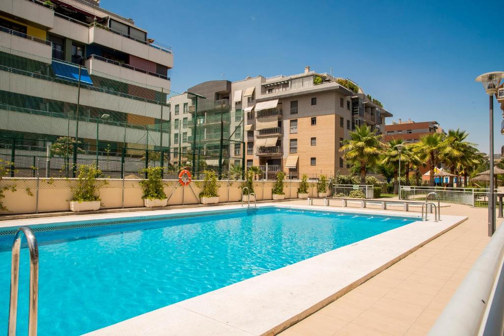 a swimming pool in a city with buildings at EnjoyGranada LUJO Piscina y Parking in Granada