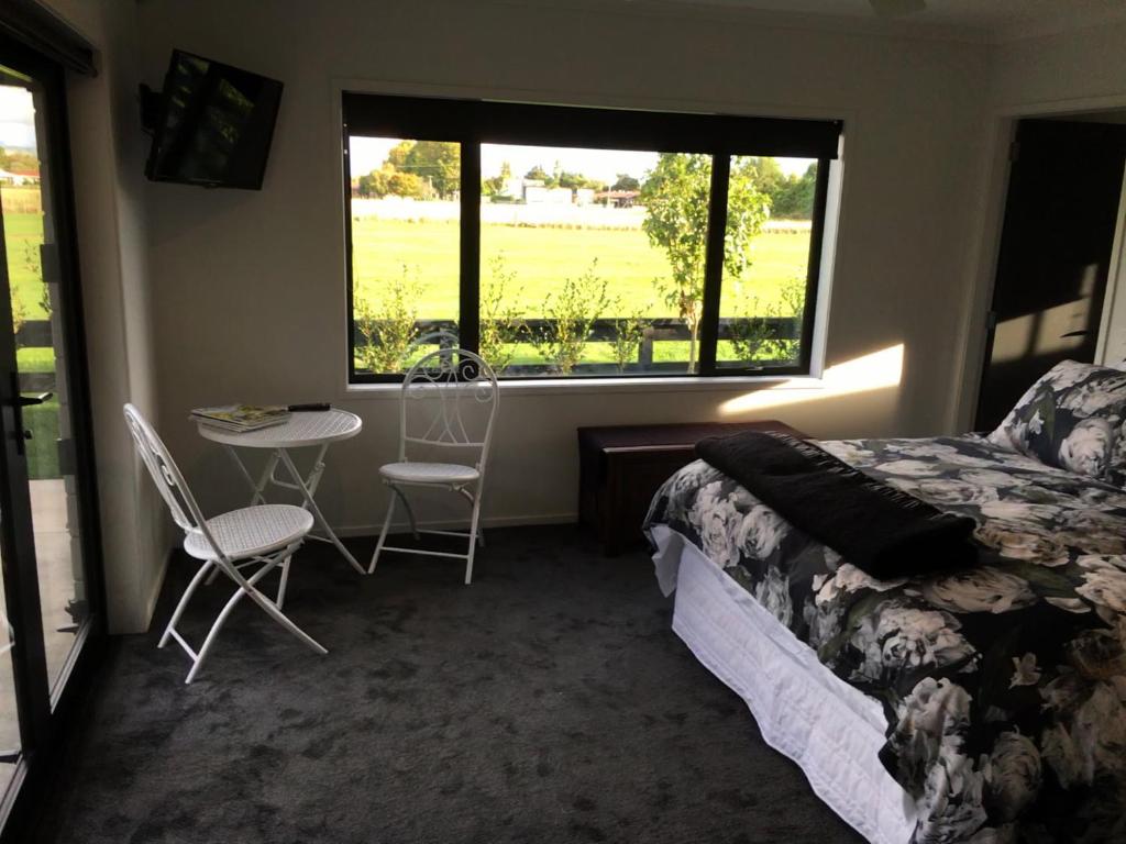 Schlafzimmer mit einem Bett, einem Tisch und Stühlen in der Unterkunft Homestead 22 in Cambridge