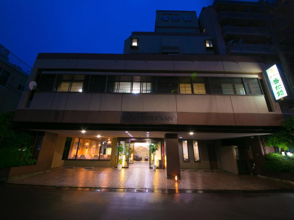 un edificio de noche con sus luces encendidas en ホテル盛松館, en Shizuoka