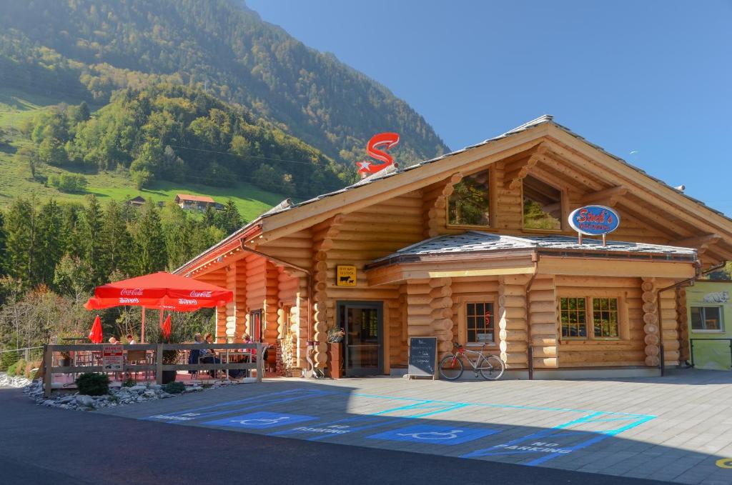 ein Blockhaus mit einem roten Regenschirm davor in der Unterkunft Loft-Inn in Mülenen 