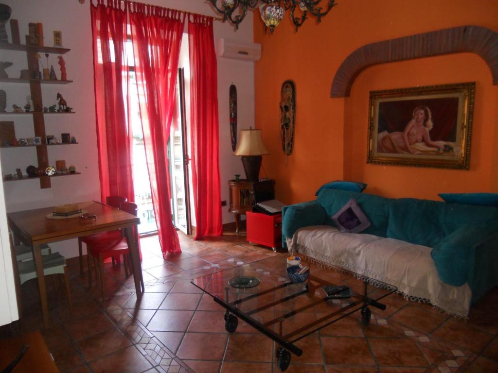 a living room with a blue couch and red curtains at B&B Casa Tua in Naples