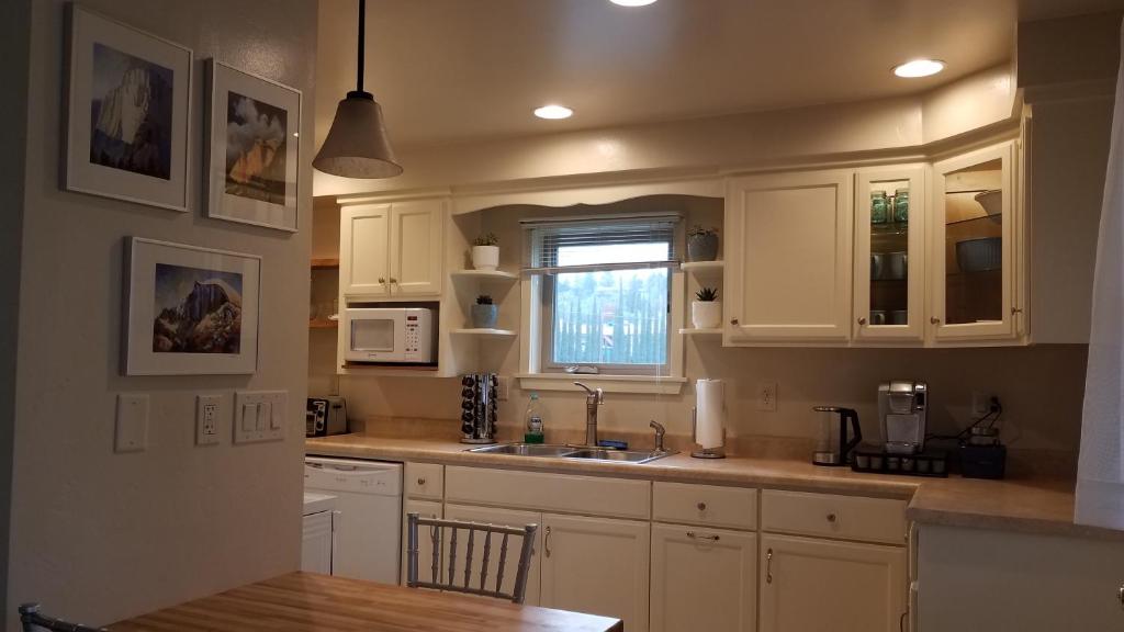 a kitchen with white cabinets and a sink and a window at Becky's Condo in Mariposa