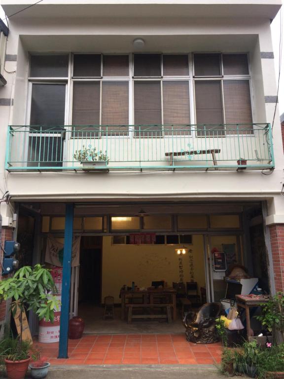 南庄的住宿－老寮Hostel，一座带桌子和桌子的阳台的建筑