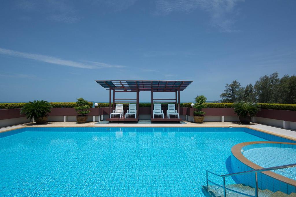 a swimming pool with two chairs and a gazebo at Avatara condo B22 A in Mae Pim